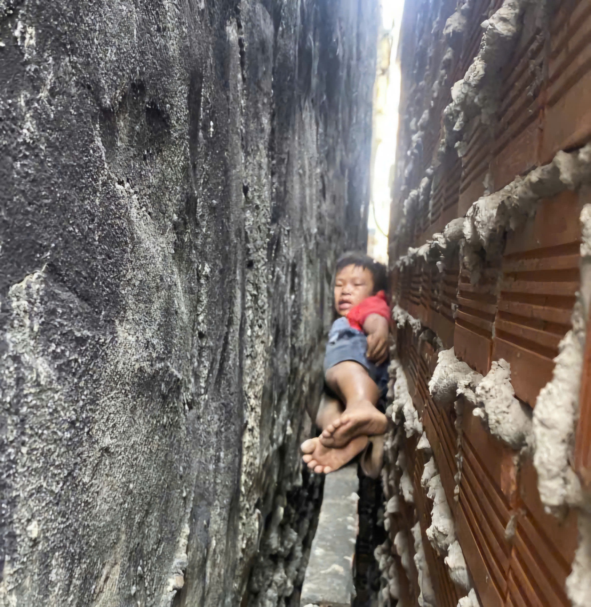 Giải cứu b&eacute; trai mắc kẹt giữa hai bức tường khi leo m&aacute;i nh&agrave; bắt m&egrave;o - Ảnh 1.