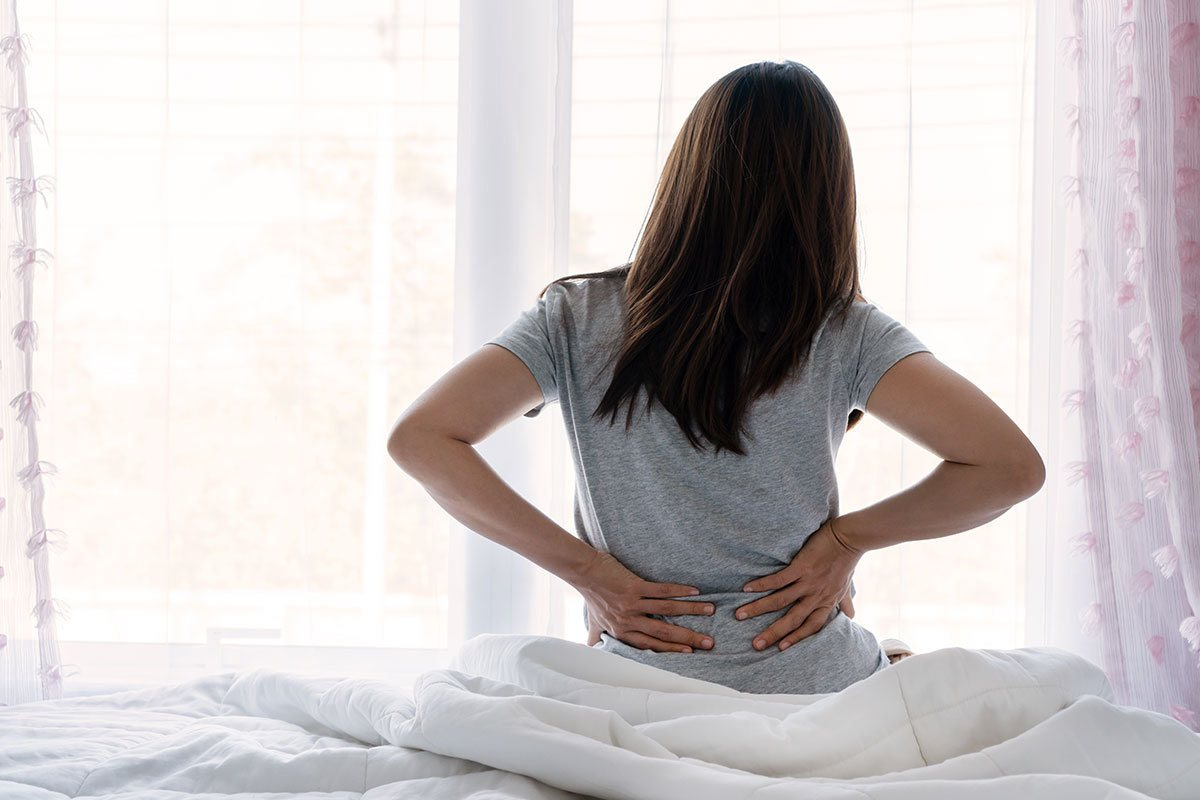 Người phụ nữ mệt mỏi thức dậy với cơn đau lưng dai dẳng