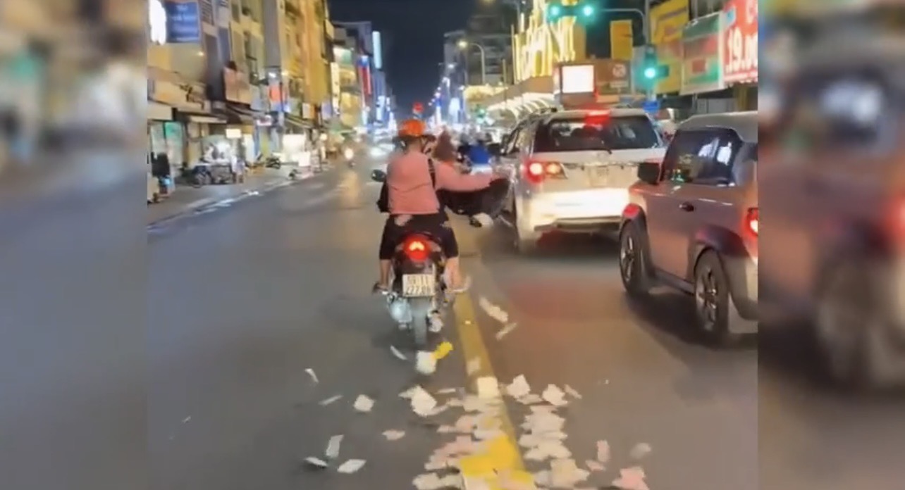 H&agrave;nh động bất ngờ của Người phụ nữ rải giấy tiền giữa đường ở TP . HCM - Ảnh 1.