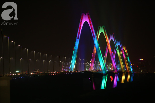 Người dân Hà Nội lên cầu chụp ảnh trong tối đầu tiên cầu Nhật Tân lên đèn triệu sắc màu - Ảnh 1.