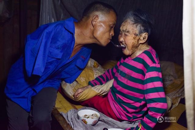 Xót cảnh người con không tay, dùng miệng bón thức ăn cho mẹ già liệt giường 91 tuổi - Ảnh 1.