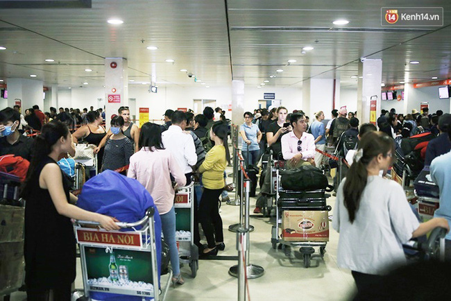 Chùm ảnh: Cận Tết, biển người vật vã hàng tiếng đồng hồ chờ check in ở sân bay Tân Sơn Nhất - Ảnh 1.