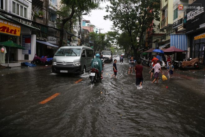 Trẻ em bơi giữa đường phố Sài Gòn sau cơn mưa lớn - Ảnh 2.