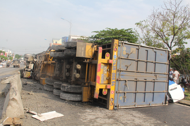 Quảng Nam: Xe container mất lái bị lật nghiêng giữa QL1A, người dân giúp tài xế thu gom hàng hóa đổ ra đường - Ảnh 1.