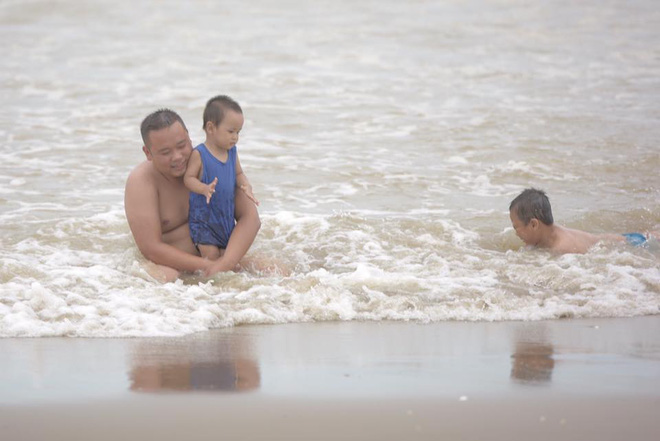 Chùm ảnh: Bất chấp sóng to gió lớn sau bão số 2, nhiều gia đình vẫn đưa trẻ em ra tắm biển Cửa Lò - Ảnh 4.