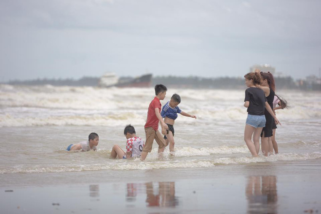 Chùm ảnh: Bất chấp sóng to gió lớn sau bão số 2, nhiều gia đình vẫn đưa trẻ em ra tắm biển Cửa Lò - Ảnh 7.