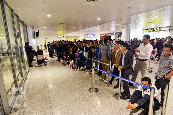 Sân bay Nội Bài chật kín chỗ vì người nhà chờ đón họ hàng về ăn quê Tết - Ảnh 2.