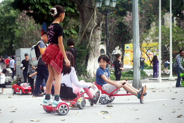 Hà Nội: Xe điện tự hành biến tướng, trẻ nhỏ thi nhau đua ở phố đi bộ - Ảnh 6.