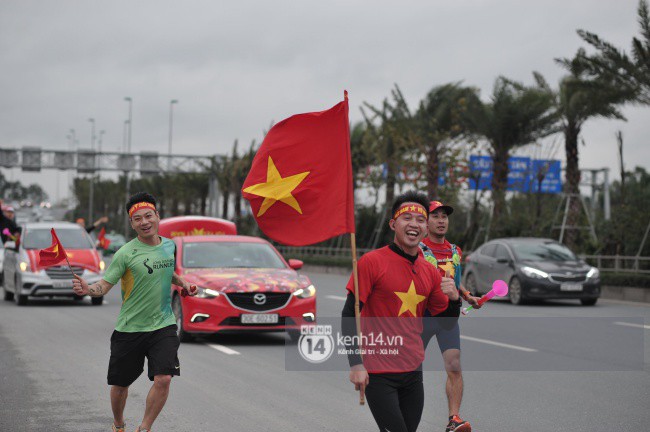 Chùm ảnh: Người hâm mộ cầm cờ Tổ quốc, chạy bộ ra sân bay Nội Bài để đón U23 Việt Nam - Ảnh 6.