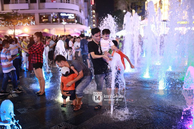 Sài Gòn tối mùng 1 Tết: Trẻ em thích thú cởi áo, nhảy vào đài phun nước đường hoa Nguyễn Huệ để nô đùa - Ảnh 16.