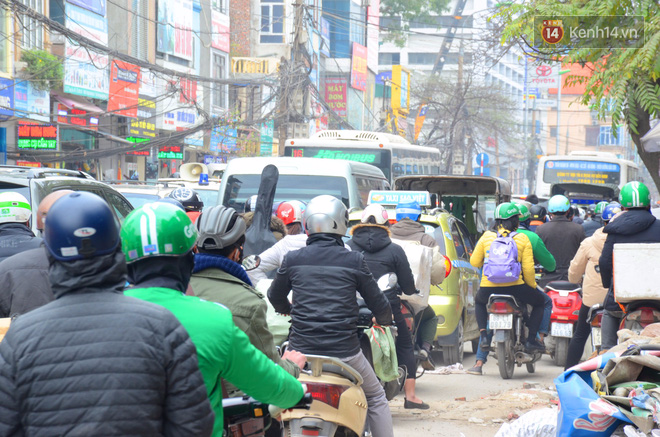 Cận Tết nguyên đán, Hà Nội ùn tắc kinh hoàng từ ngõ ra phố, người dân vác cả xe qua dải phân cách - Ảnh 2.