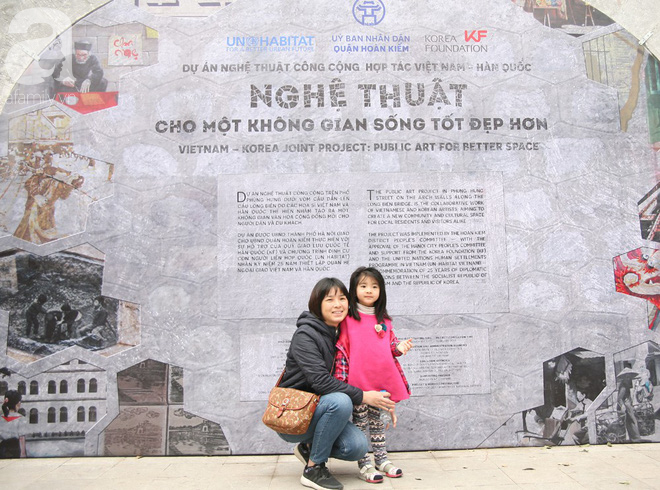 Người Hà Nội xúng xính áo dài Tết chụp ảnh trước cổng vòm phố Phùng Hưng - Ảnh 1.