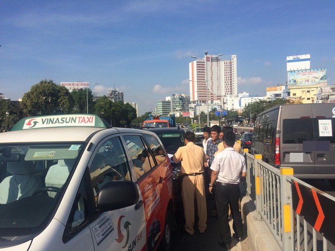 Va chạm 3 xe ô tô ở cầu vượt Hàng Xanh, đôi vợ chồng cùng con nhỏ hoảng loạn kêu cứu bên trong taxi - Ảnh 1.