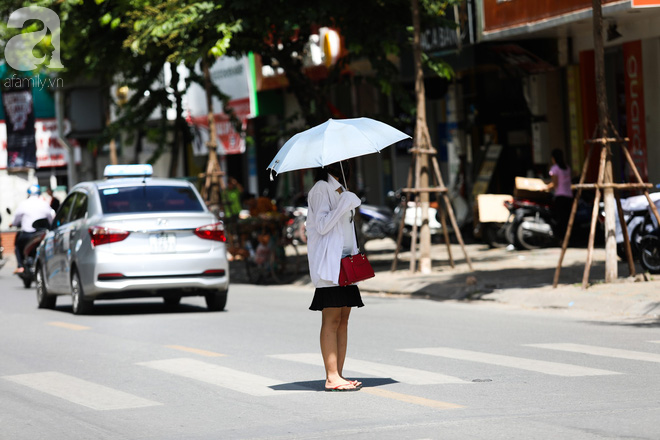 Nắng nóng hơn 40 độ C, người dân Hà Nội chật vật tránh nắng từ sáng sớm - Ảnh 8.