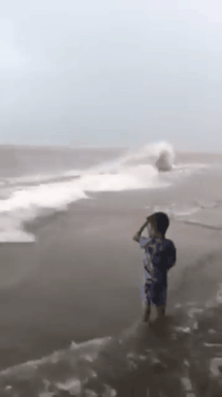 Clip: Mẹ thản nhiên để con chơi đùa cùng lớp sóng lớn bên bờ biển rồi ngồi quay video - Ảnh 1.