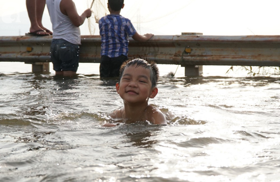 Hà Nội: Người lớn cùng trẻ nhỏ thích thú bơi lội... giữa đường quốc lộ thời ngập lụt - Ảnh 2.