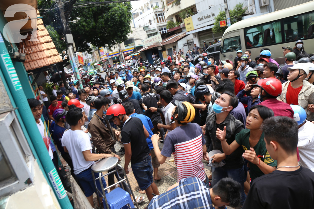 Hàng trăm thanh niên bất chấp nguy hiểm leo tường, chen nhau để giật đồ cúng cô hồn ở Sài Gòn - Ảnh 7.