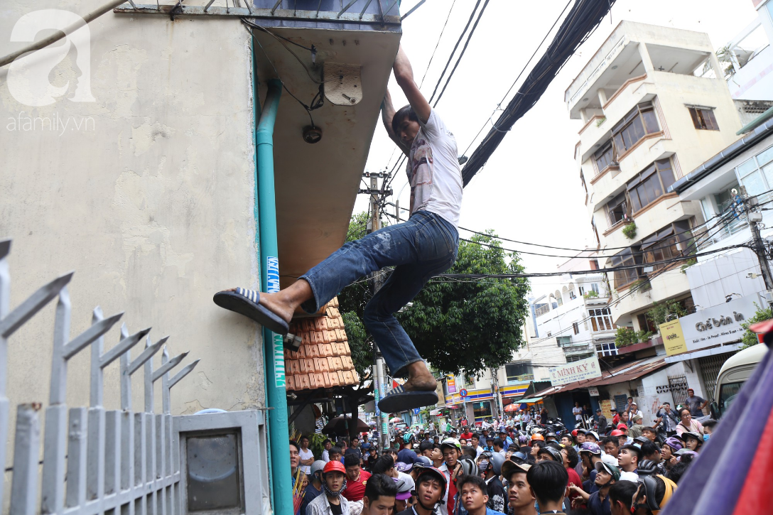 Hàng trăm thanh niên bất chấp nguy hiểm leo tường, chen nhau để giật đồ cúng cô hồn ở Sài Gòn - Ảnh 4.
