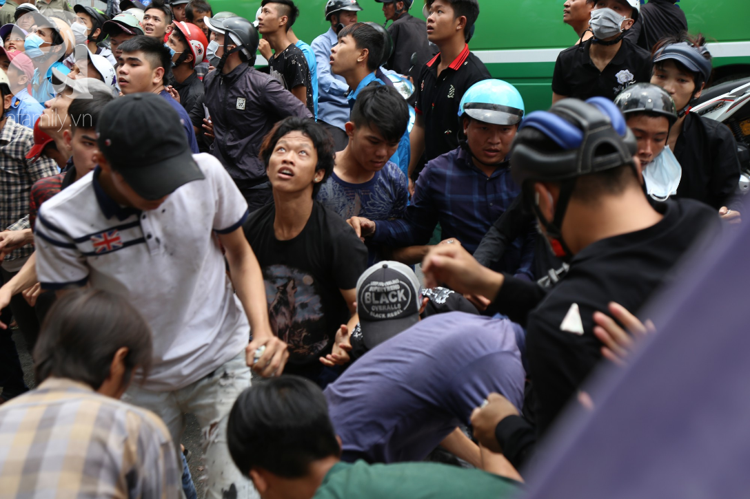 Hàng trăm thanh niên bất chấp nguy hiểm leo tường, chen nhau để giật đồ cúng cô hồn ở Sài Gòn - Ảnh 1.