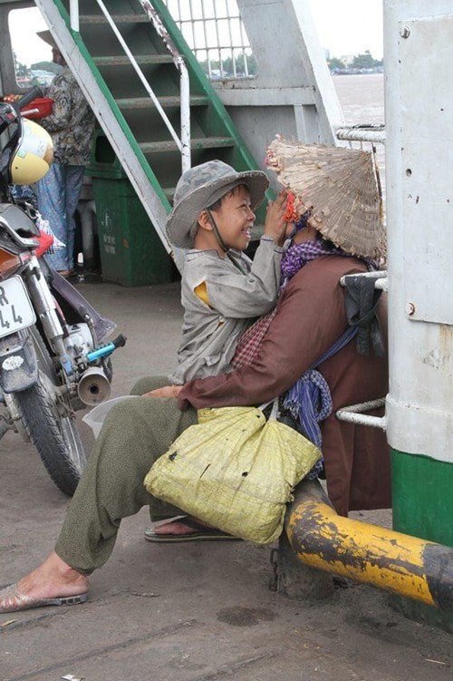 Nụ cười của đứa trẻ ăn xin dành cho mẹ trên chuyến phà mưu sinh xuôi ngược - bức ảnh giản dị nhưng khiến hàng ngàn người ấm áp - Ảnh 1.