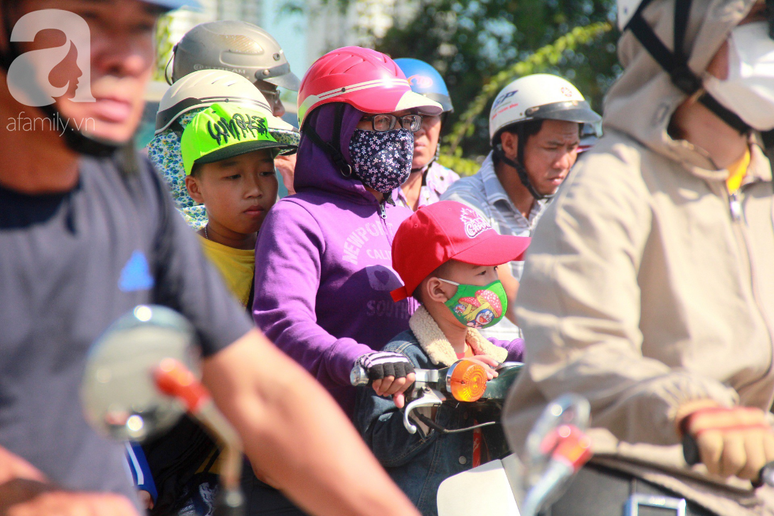 Sài Gòn nắng kinh hoàng sau Tết, người lớn trùm kín như Ninja, trẻ em mệt mỏi gục trên xe - Ảnh 9.