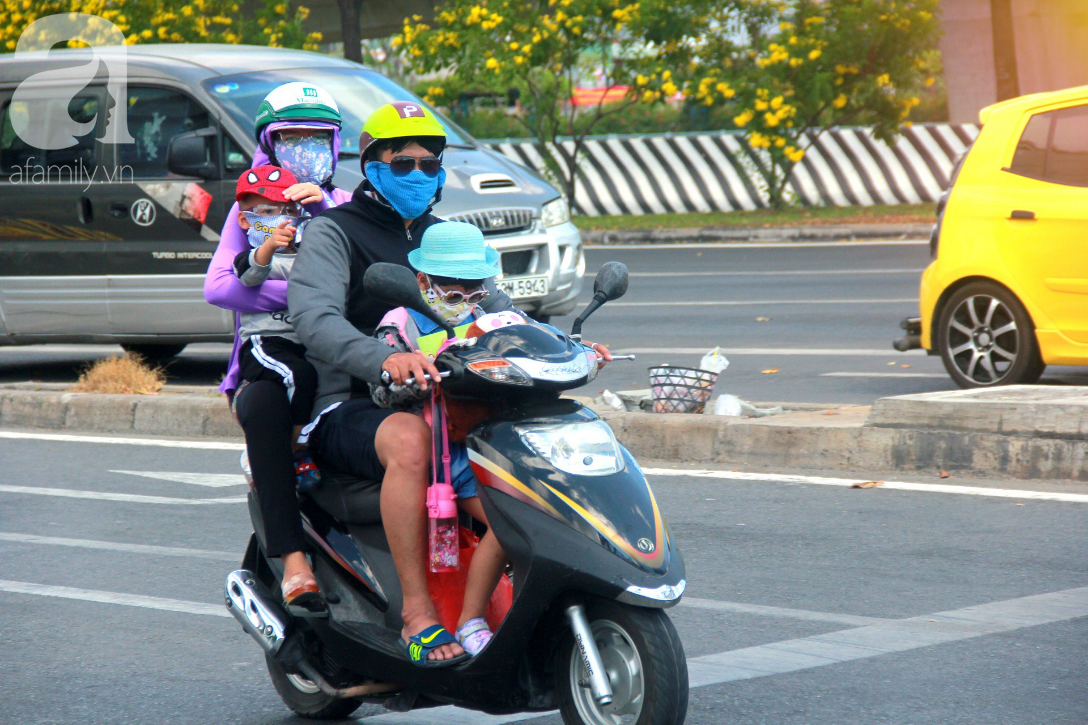 Sài Gòn nắng kinh hoàng sau Tết, người lớn trùm kín như Ninja, trẻ em mệt mỏi gục trên xe - Ảnh 2.