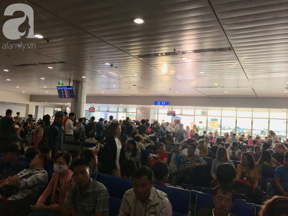 Chiều tối 30 Tết, hàng ngàn người nằm vật vờ tại sân bay Tân Sơn Nhất, mong không delay để về đón giao thừa - Ảnh 1.