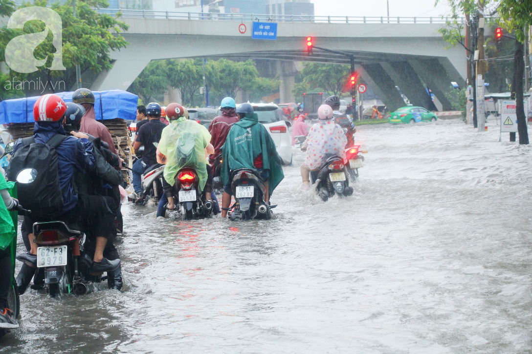Mưa lớn kéo dài hơn 30 phút, người Sài Gòn bì bõm lội nước, té ngã vì nhiều tuyến đường ngập nặng - Ảnh 8.