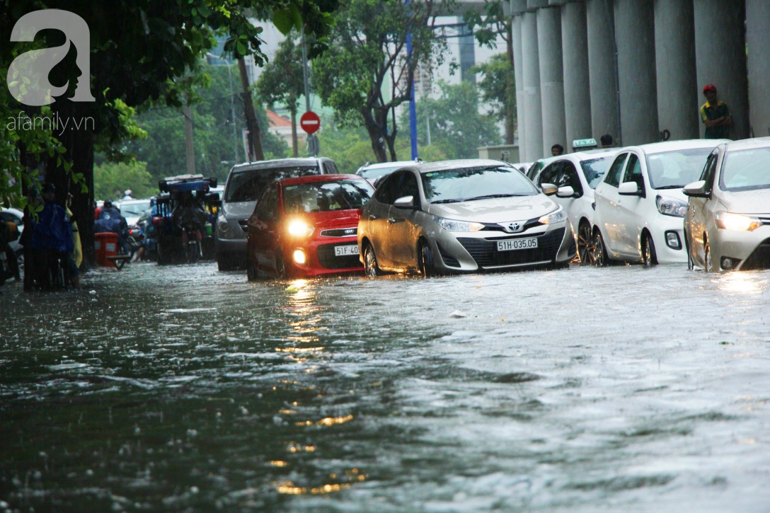 Mưa lớn kéo dài hơn 30 phút, người Sài Gòn bì bõm lội nước, té ngã vì nhiều tuyến đường ngập nặng - Ảnh 2.