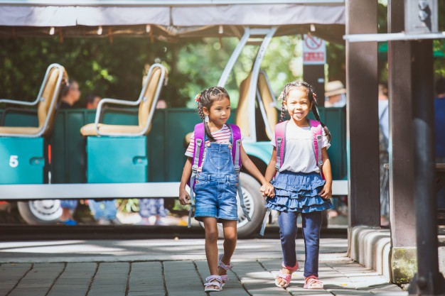 asian-pupil-kids-with-backpack-holding-hand-going-school-with-school-bus-together_7186-2149