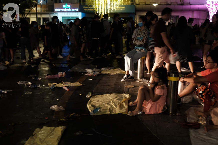Ảnh: Phố đi bộ Nguyễn Huệ &quot;ngập rác&quot; sau màn pháo hoa sau đêm Countdown, trẻ em mệt mỏi chờ bố mẹ - Ảnh 10.