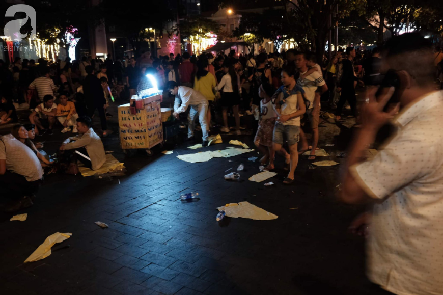 Ảnh: Phố đi bộ Nguyễn Huệ &quot;ngập rác&quot; sau màn pháo hoa sau đêm Countdown, trẻ em mệt mỏi chờ bố mẹ - Ảnh 6.
