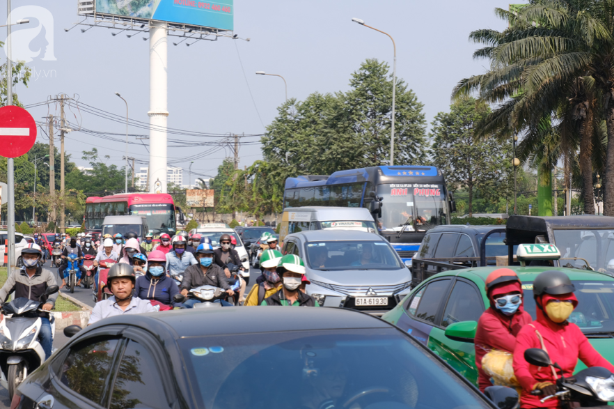 Hàng ngàn cha mẹ đội nắng chở con nhỏ về quê ăn Tết, các cửa ngõ Sài Gòn ùn ứ - Ảnh 1.