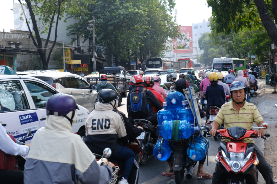 Hàng ngàn cha mẹ đội nắng chở con nhỏ về quê ăn Tết, các cửa ngõ Sài Gòn ùn ứ - Ảnh 14.