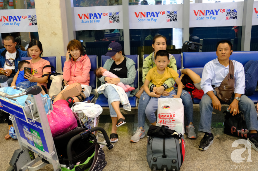 Cận ngày giao thừa, sân bay Tân Sơn Nhất lại “vỡ trận”: Biển người chờ la liệt, trẻ mệt nhoài theo bố mẹ về quê - Ảnh 4.