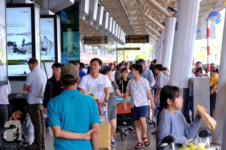 Cận ngày giao thừa, sân bay Tân Sơn Nhất lại “vỡ trận”: Biển người chờ la liệt, trẻ mệt nhoài theo bố mẹ về quê - Ảnh 6.