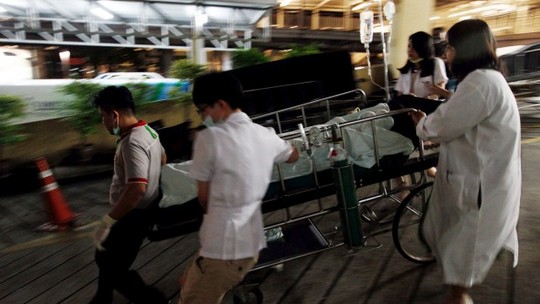 Medical workers rush the victim of a blast at the Erawan Shrine to a nearby hospital in central Bangkok.