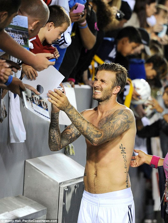 David Beckham lưng trần ôm fan nữ