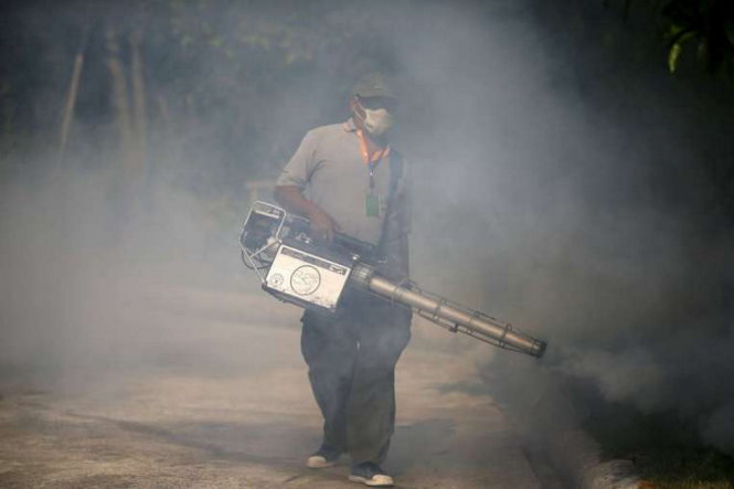 Nhân viên y tế phun thuốc diệt muỗi ở một ngôi làng tại Bangkok, Thái Lan - Ảnh: Reuters