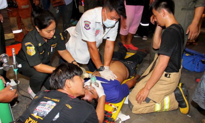 Một nạn nhân trong vụ tai nạn đang được lực lượng y tế trợ giúp - Ảnh: Reuters