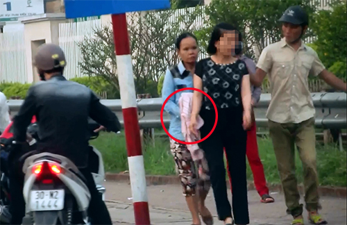 Hà Nội: Bị bắt quả tang dàn cảnh móc túi trước cổng BV Bạch Mai, người phụ nữ nằm ra đường, lột quần ăn vạ - Ảnh 2.