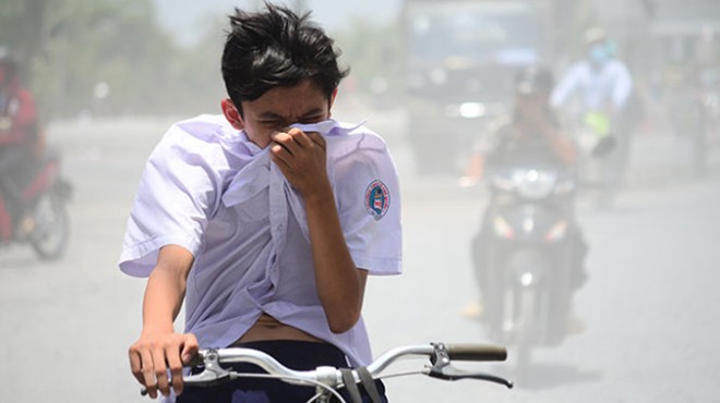 Một học sinh Trường THCS Ngô Chí Quốc mỗi ngày đi học phải hứng chịu bụi mù mịt của con đường