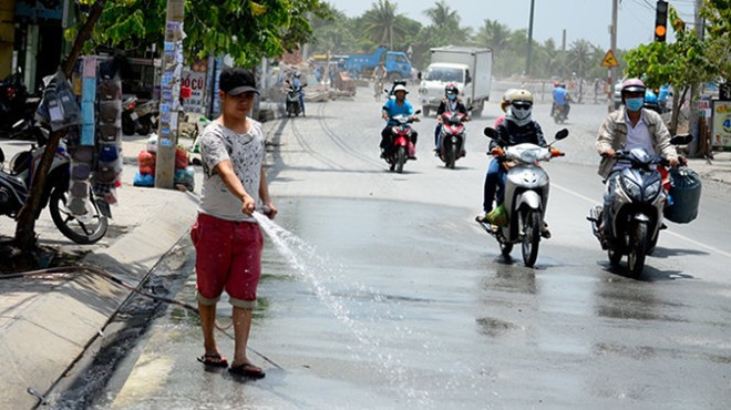 Anh Lê Hồng Huy tưới nước lần thứ hai trong ngày chống bụi trên đường