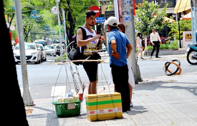 Vị khách nước ngoài bị một người bán dừa chèo kéo, ép mua hai trái dừa tươi với giá 200.000 đồng ngay khu vực ngã tư Nam Kỳ Khởi Nghĩa - Nguyễn Thị Minh Khai (Q.1, TP.HCM) trưa 11-5.