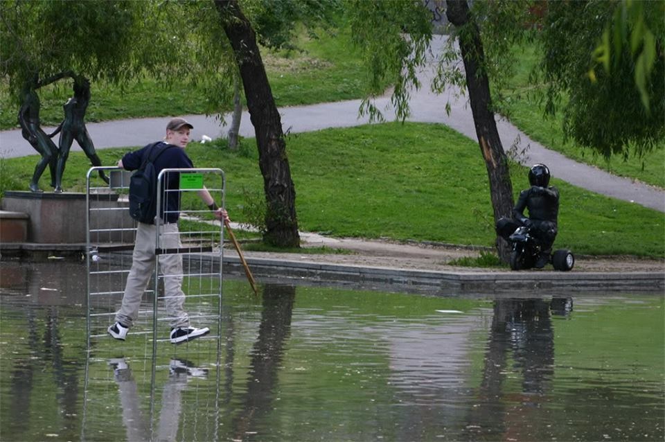 Young man wades through the water to his motionless friend.