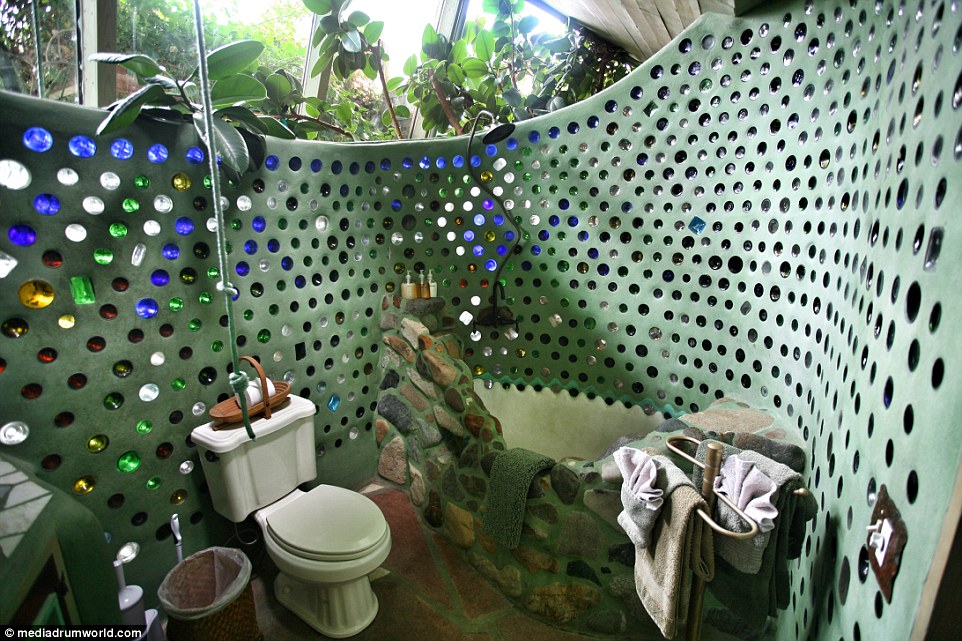 This bathroom features plenty of natural light, along with a bath inset into the unusual partition wall