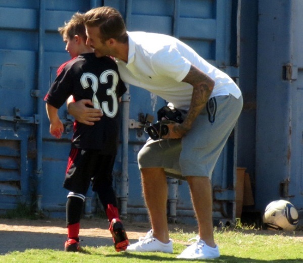 Beckham ngồi l&ecirc;n đ&ugrave;i vợ để xem đ&aacute; b&oacute;ng
