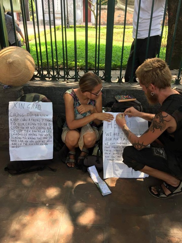 Cặp đôi người Tây với tờ giấy xin được giúp đỡ trên phố Hà Nội. (Ảnh: Otofun)