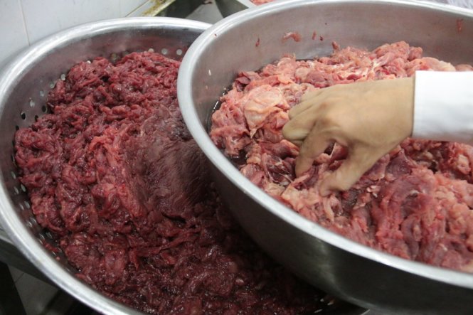 Từng miếng thịt heo đỏ nhạt sau một thời gian ngâm đã biến thành thịt bò với màu đỏ sậm - Ảnh: Tiến Long
