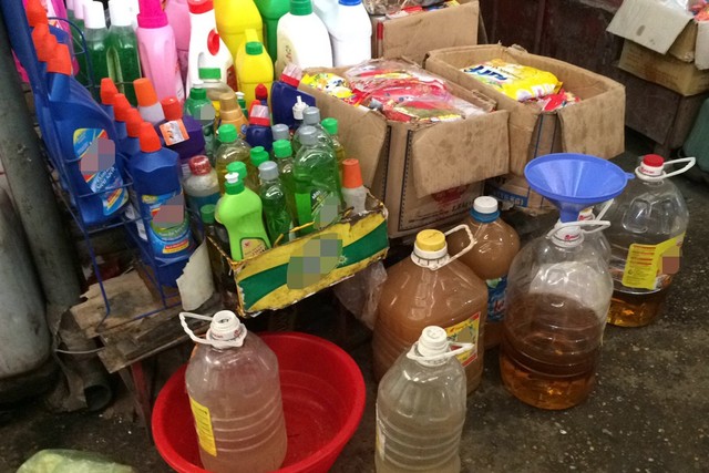 Các can dầu ăn “nước 2” đặt dưới nền nhà ở chợ Phùng Khoang, Hà Nội. Ảnh: H.Nguyên